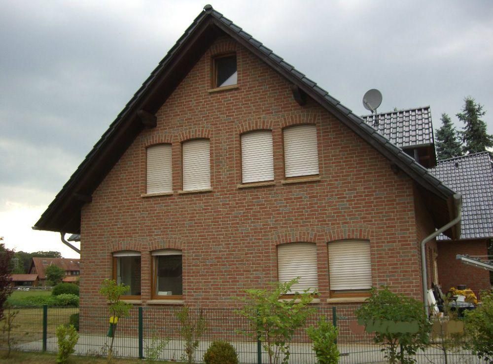 Ein Backsteinhaus mit einer Satellitenschüssel auf dem Dach