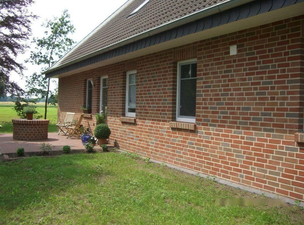Ein Backsteinhaus mit einer Terrasse davor