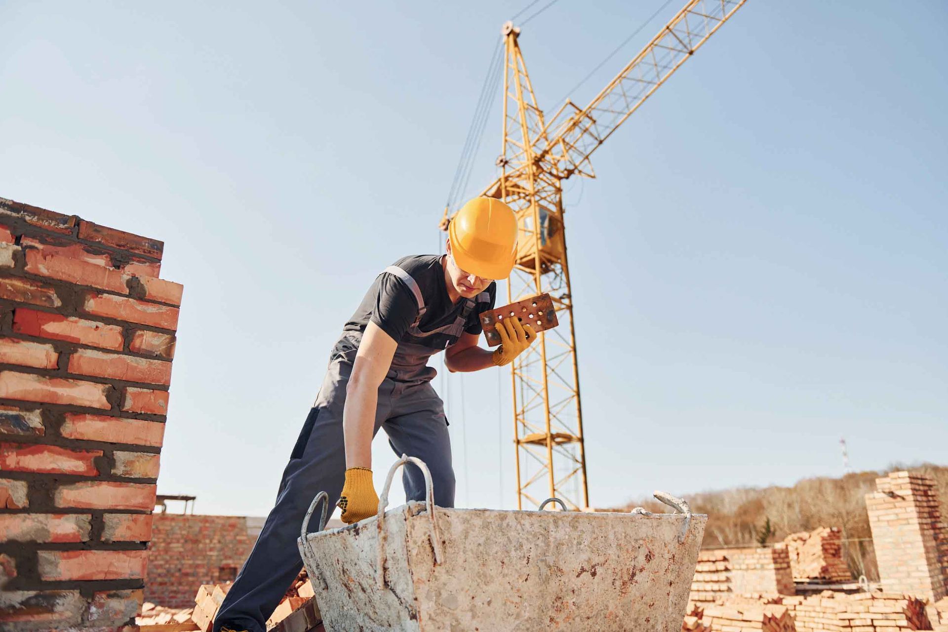 Un trabajador de la construcción está levantando un bloque de hormigón en un sitio de construcción.