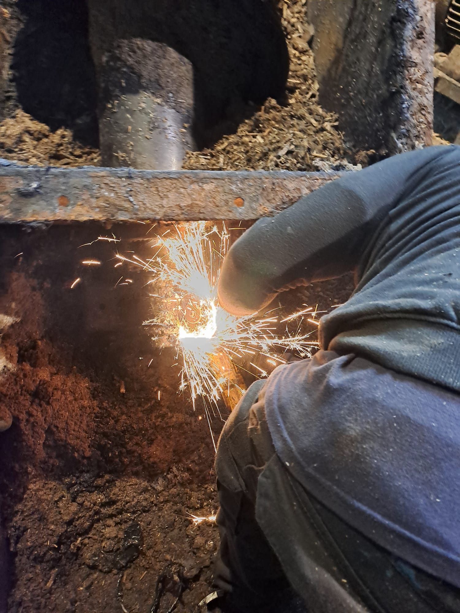 Una persona está cortando un trozo de metal del que salen chispas.