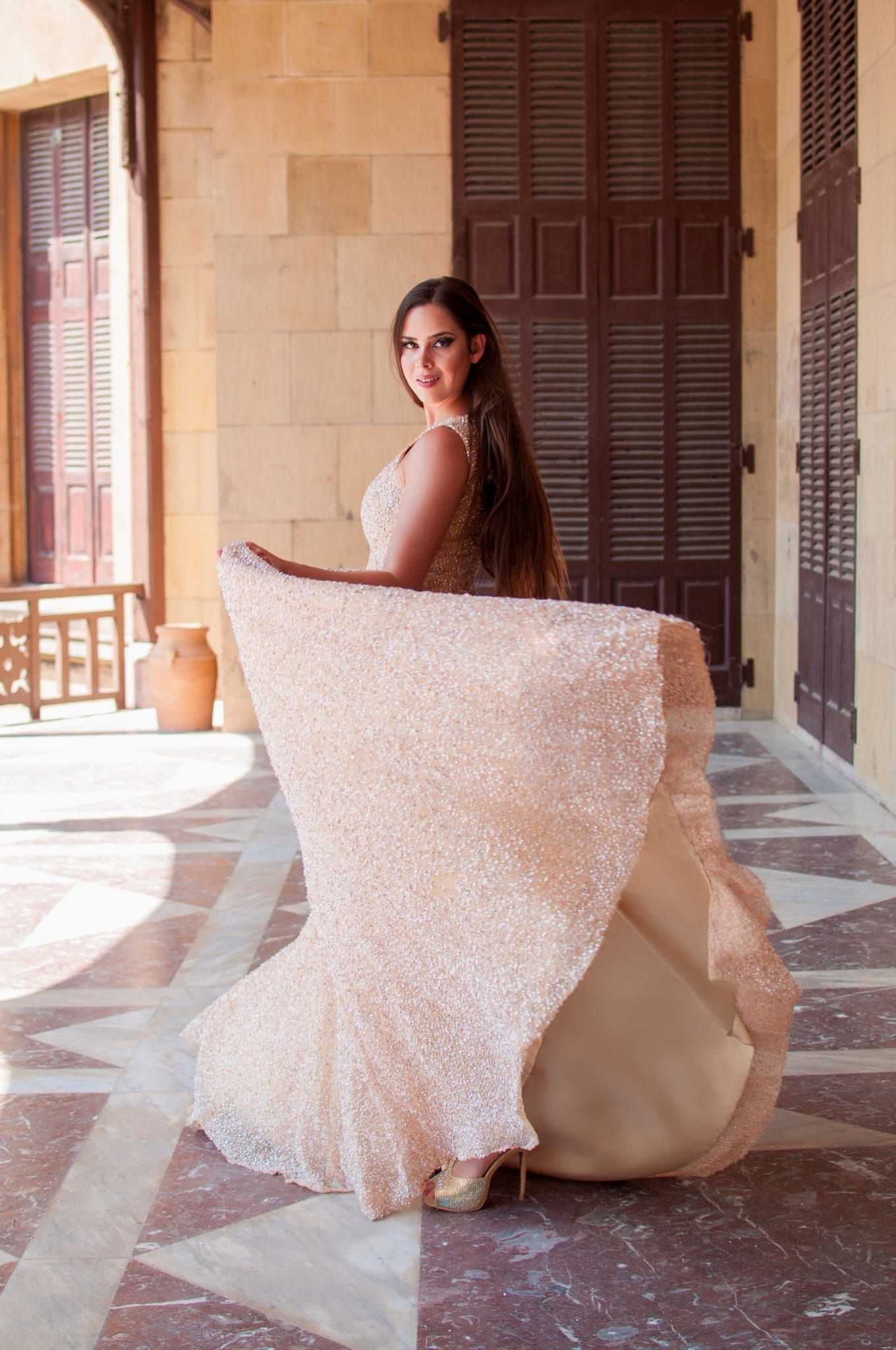 Una mujer con un vestido largo está parada en un pasillo.