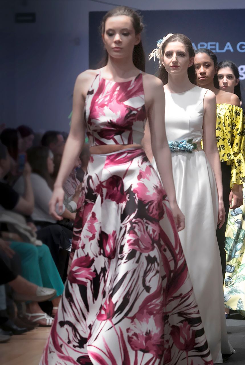 Un grupo de mujeres camina por una pasarela en un desfile de moda.