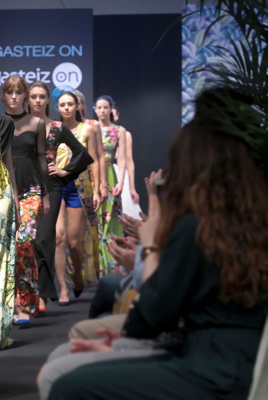 Un grupo de mujeres camina por una pasarela en un desfile de moda.