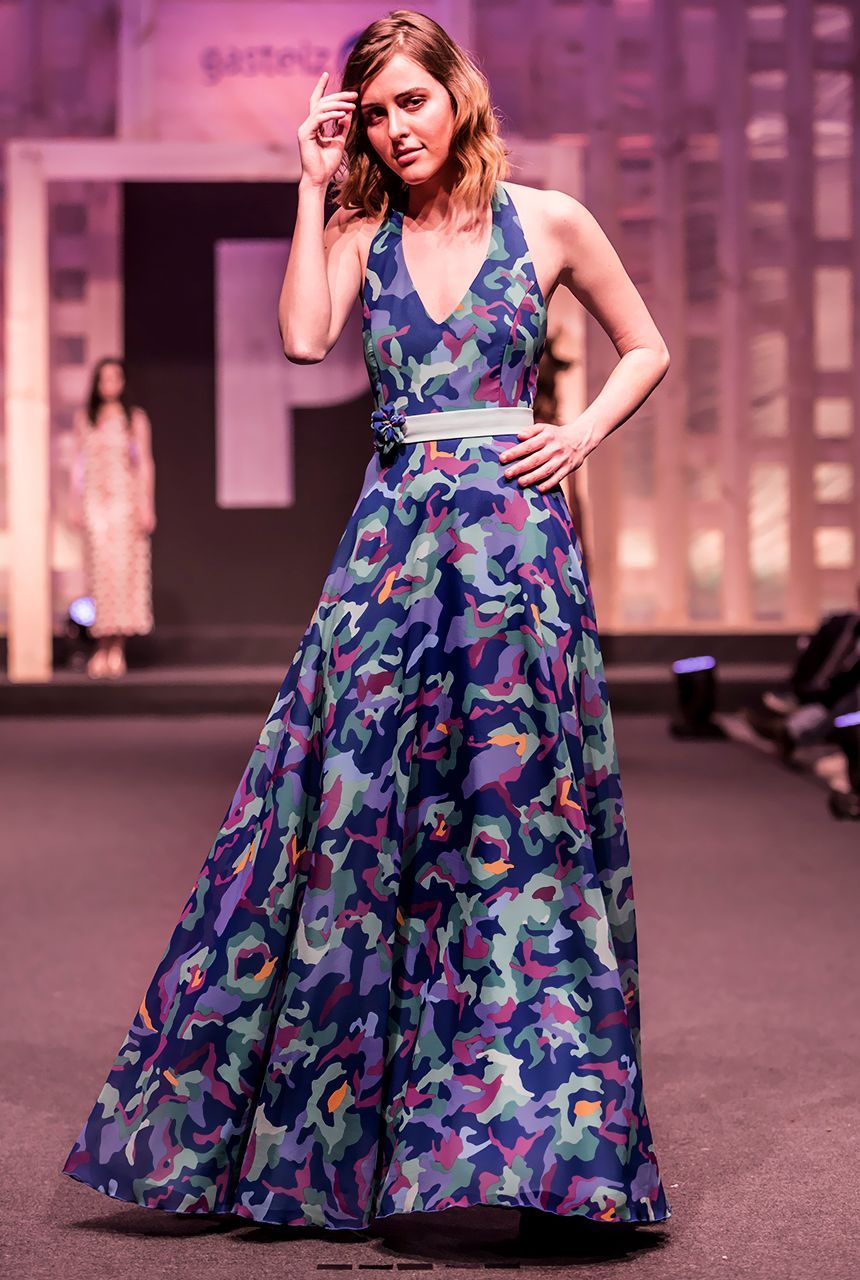 Una mujer camina por una pasarela con un vestido colorido.