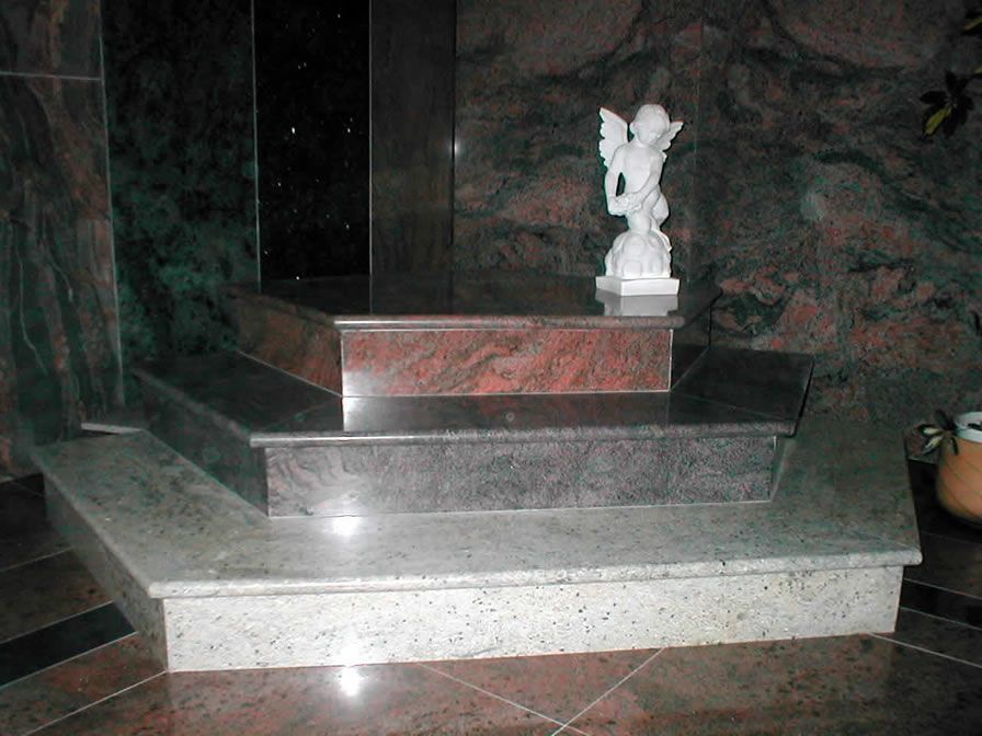 Treppe aus Marmor mit einer Engelsstatue. Roter, grauer und weißer Marmor.