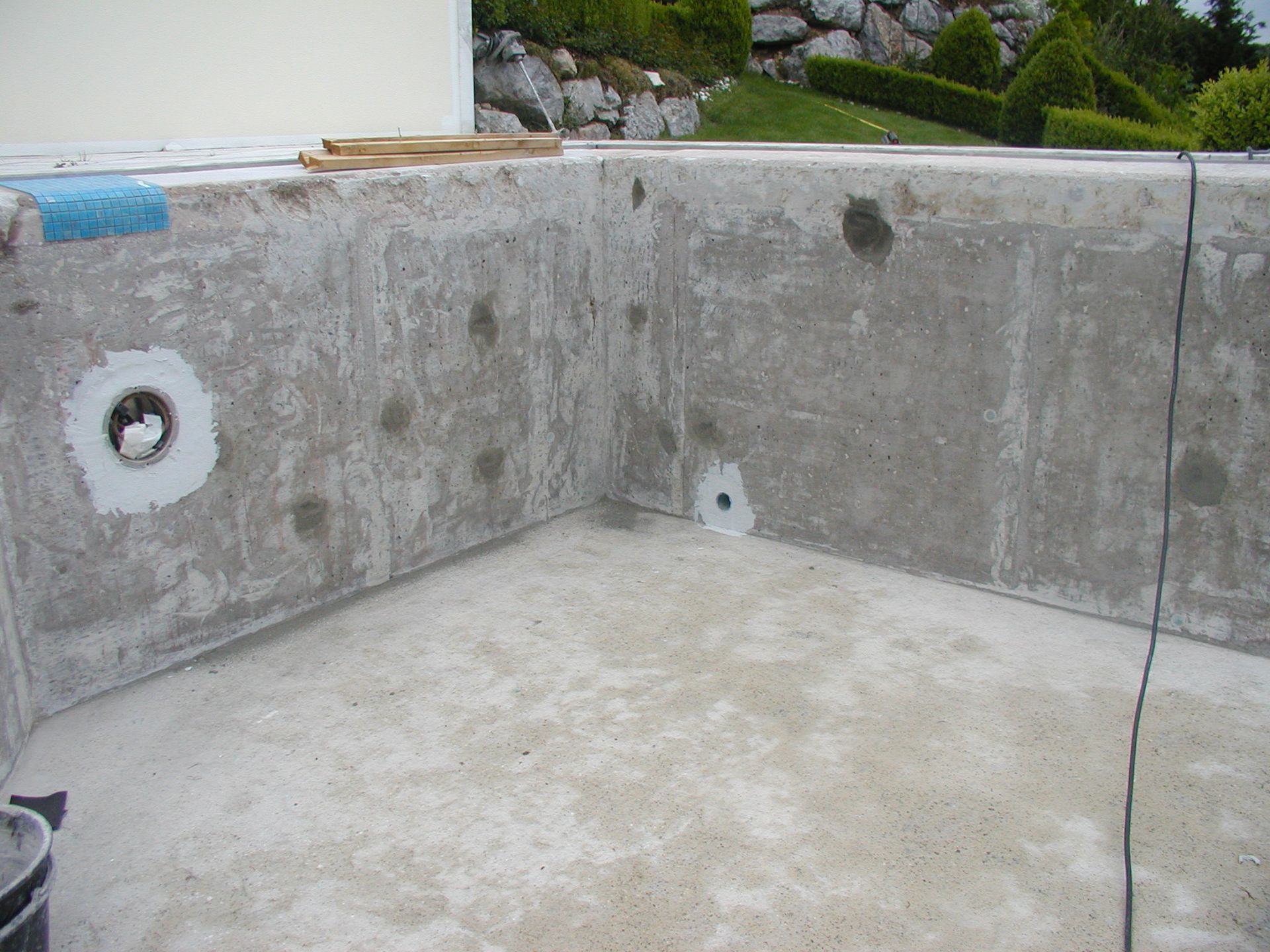 Innenansicht eines Betonpools mit Ausbesserungen und vorbereiteten Oberflächen, Eckansicht.