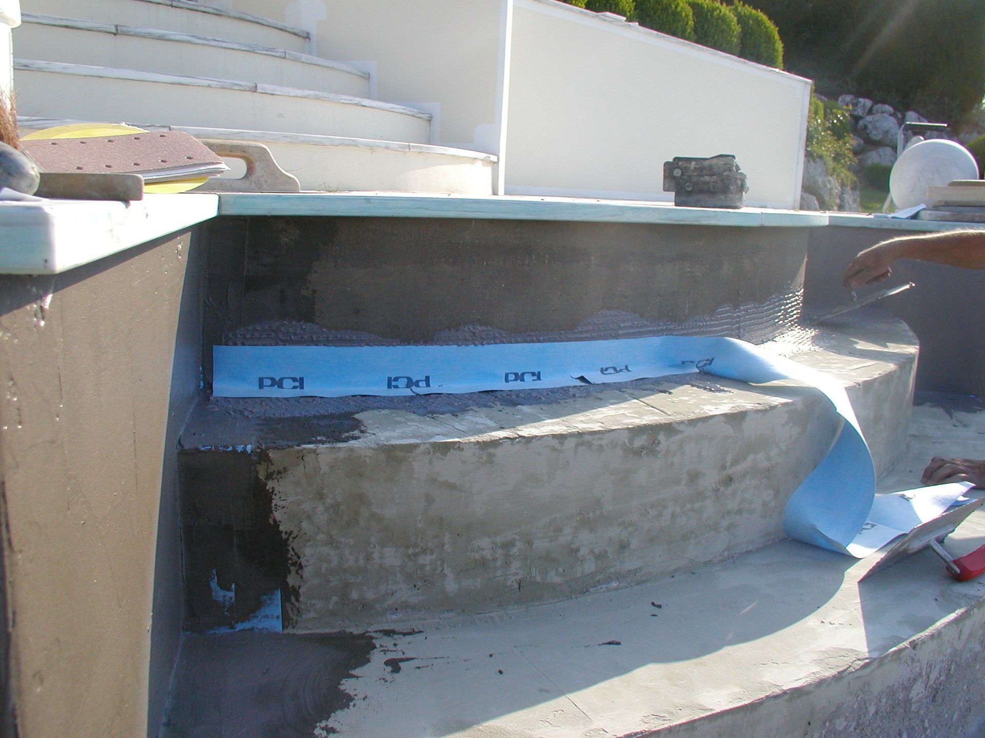 Betonstufen werden mit blauem Klebeband und Dichtungsmittel wasserdicht gemacht.