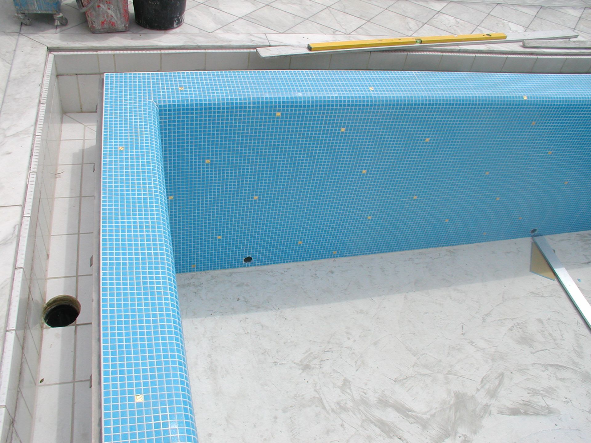 Pool im Bau, mit blauem Mosaik gefliest. Teilweise fertiggestellt. Betonumrandung.