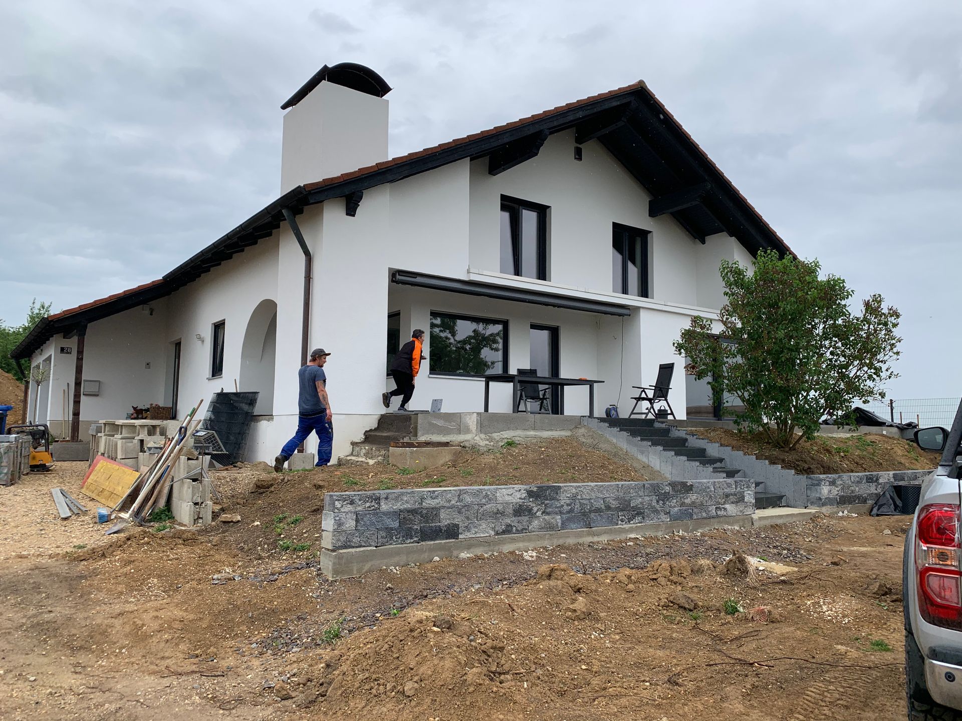 Ein weißes Haus im Bau, Arbeiter sind anwesend.