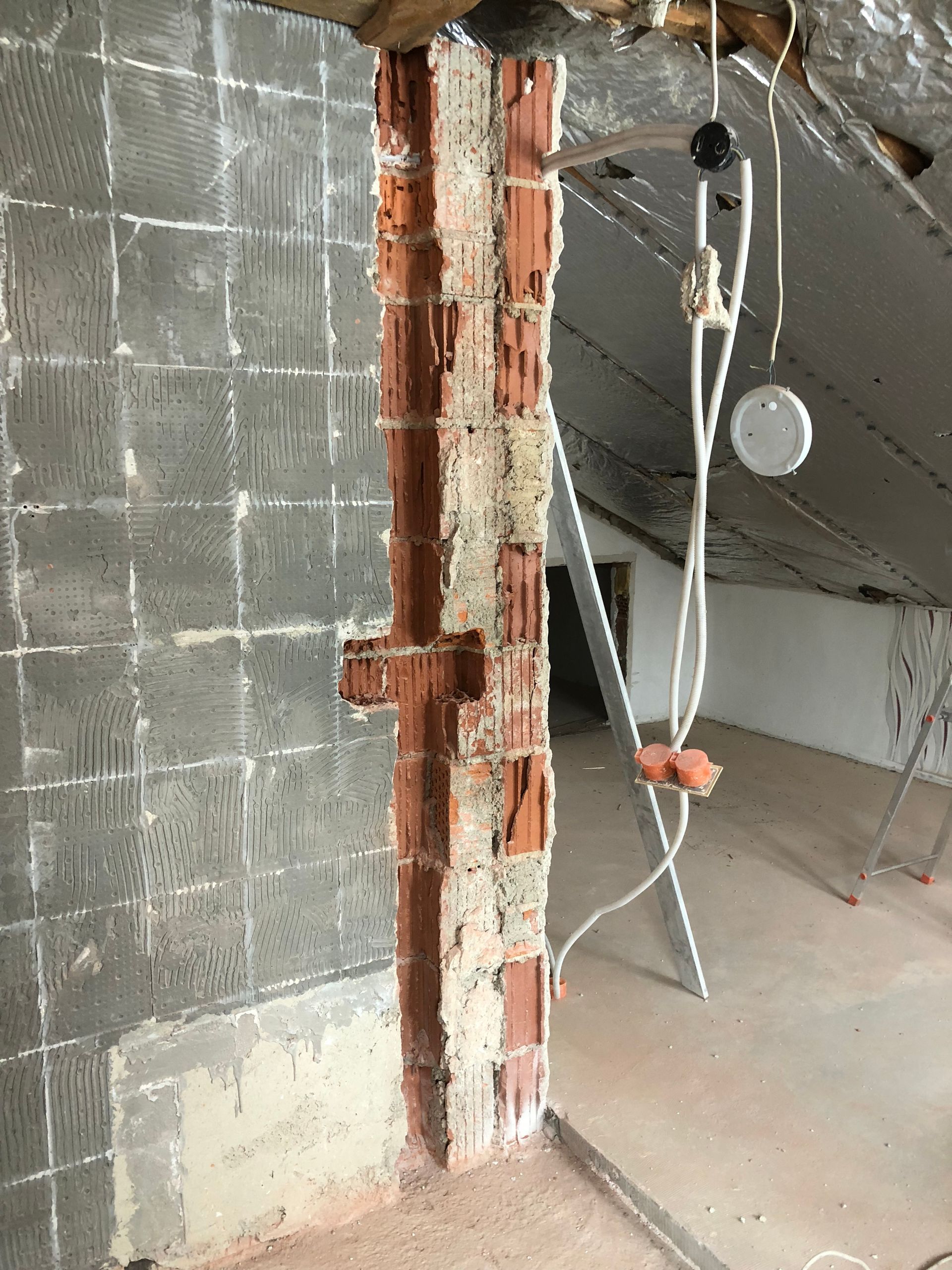 Ziegelpfeilerkonstruktion mit Sichtziegeln in einem unfertigen Raum.