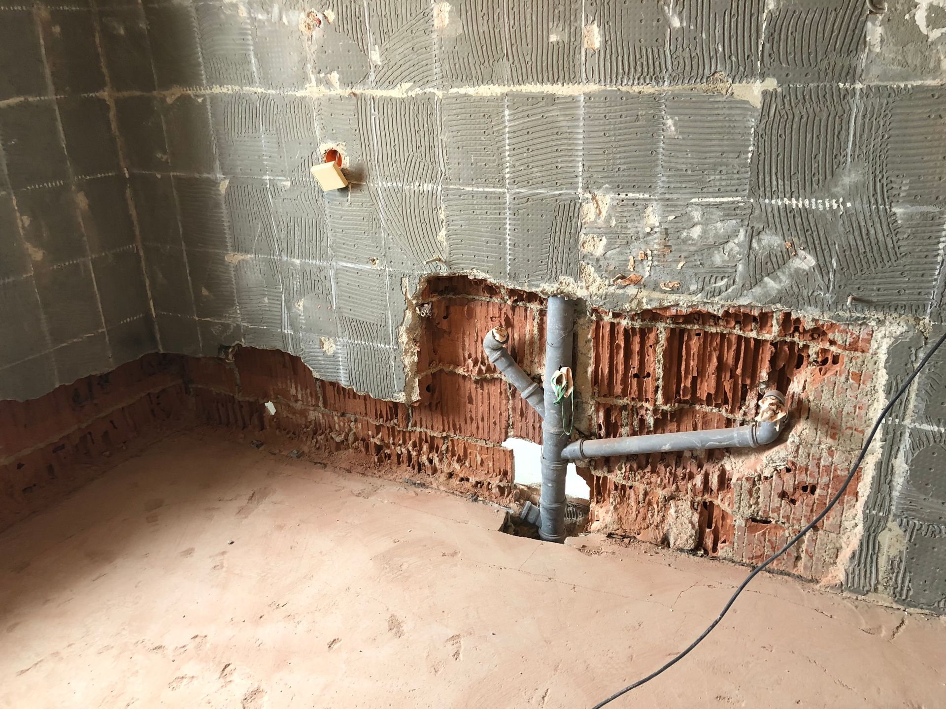 Renovierte Küche mit freiliegenden Ziegeln und Sanitärrohren.