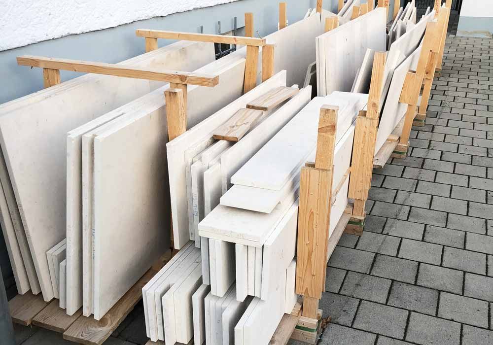 Steinplatten, die im Freien auf Holzstützen gestapelt sind, möglicherweise zum Verkauf oder zum Bau.