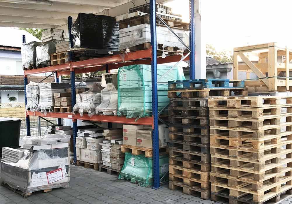 Lagerregale mit gestapelten Paletten, die verpackte Waren enthalten.