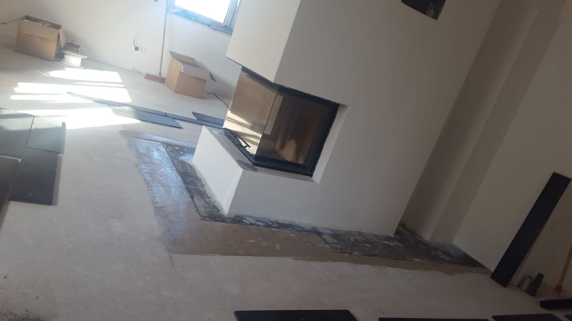 Im Bau befindlicher Kamin mit teilweise gefliestem Boden.