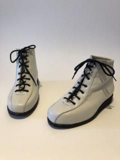 Paire de bottines à lacets et talons hauts, semelles, sur fond uni.