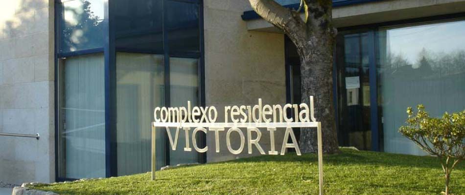Un cartel frente a un edificio que dice complejo residencial victoria