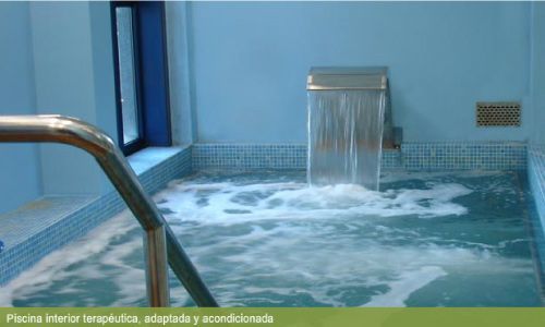 Hay una cascada en el medio de la piscina.