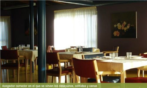 Un restaurante con mesas y sillas y un cuadro en la pared.