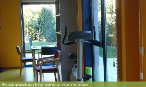 Una bicicleta estática está sentada en una habitación con sillas.