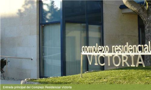 Un cartel del complejo residencial Victoria frente a un edificio.