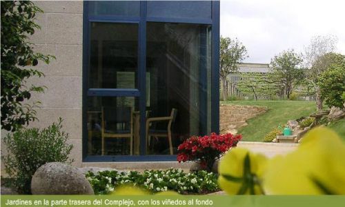 Una foto de una casa con un jardín delante de ella.