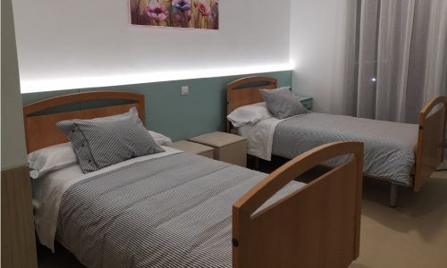 Un dormitorio con dos camas y un cuadro en la pared.