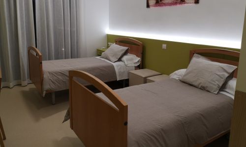 Una habitación de hotel con dos camas y una mesita de noche.