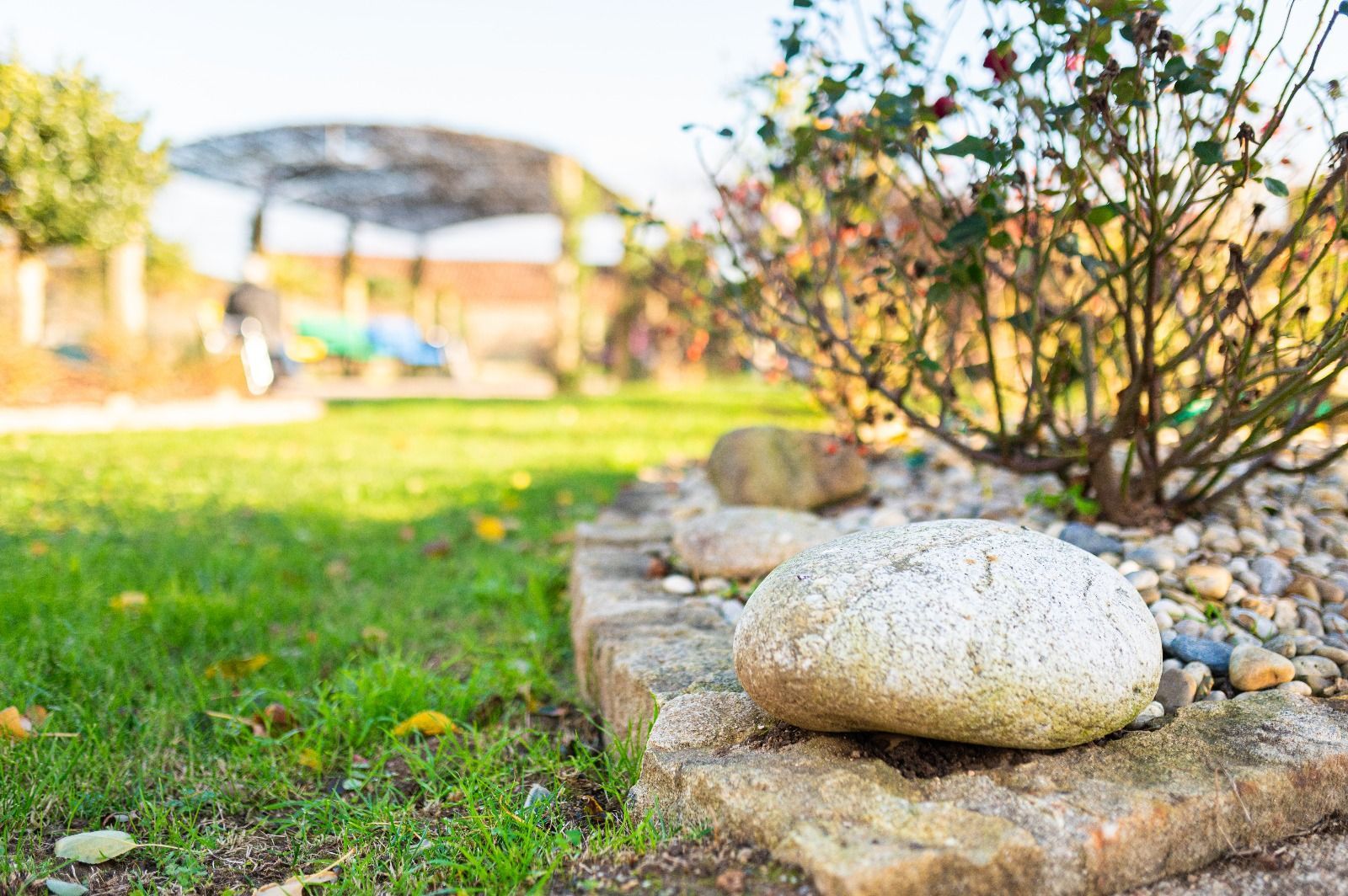 Una gran roca está encima de un ladrillo en un jardín.