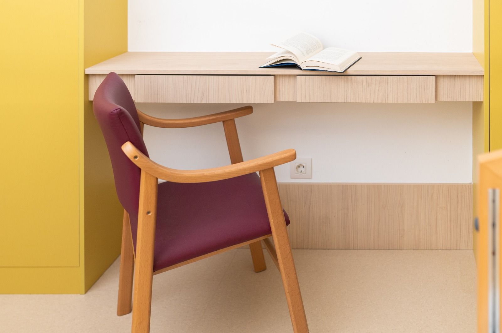Una silla está frente a un escritorio con un libro sobre ella.