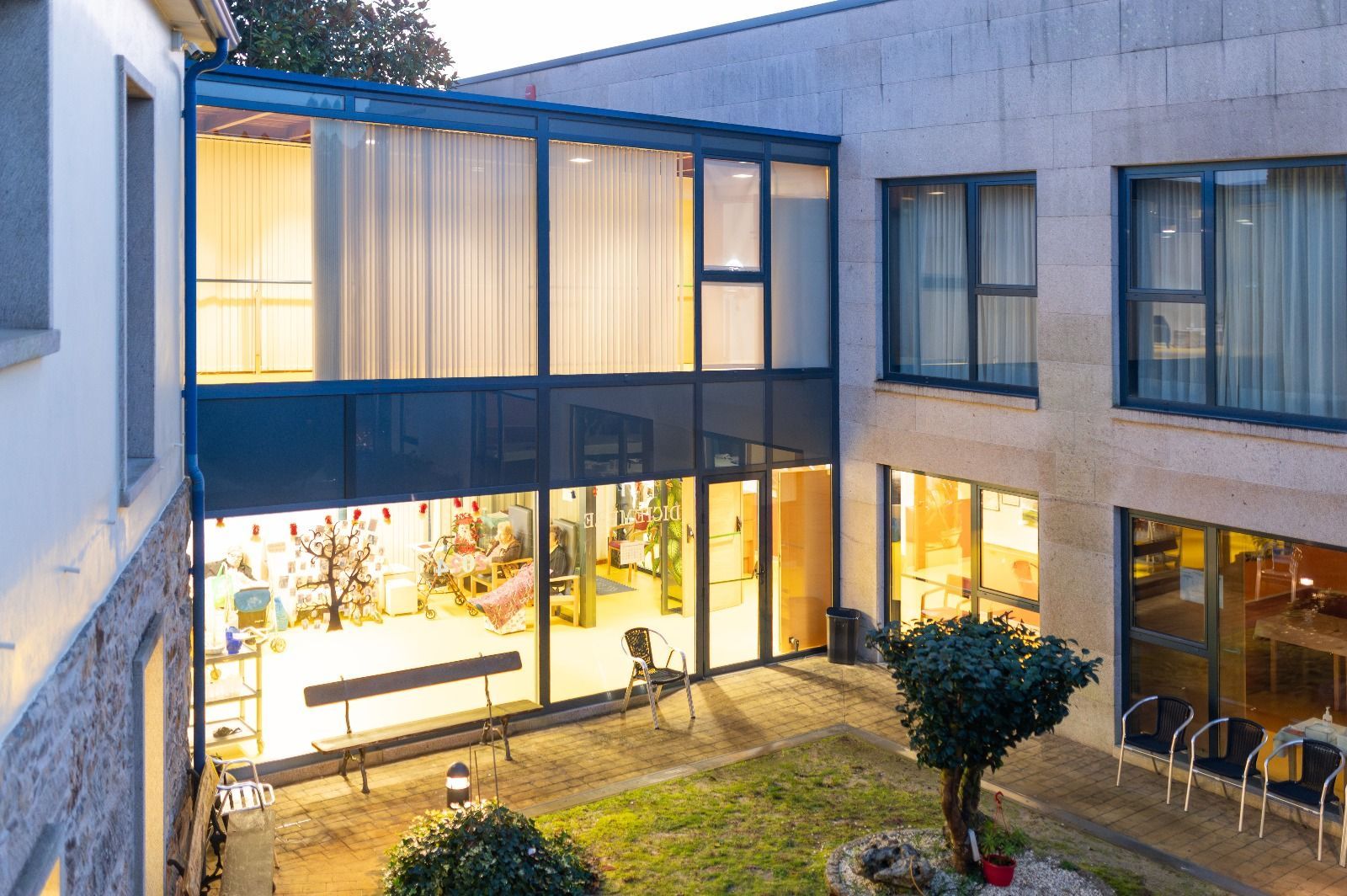 Un edificio grande con muchas ventanas tiene un patio en el medio.