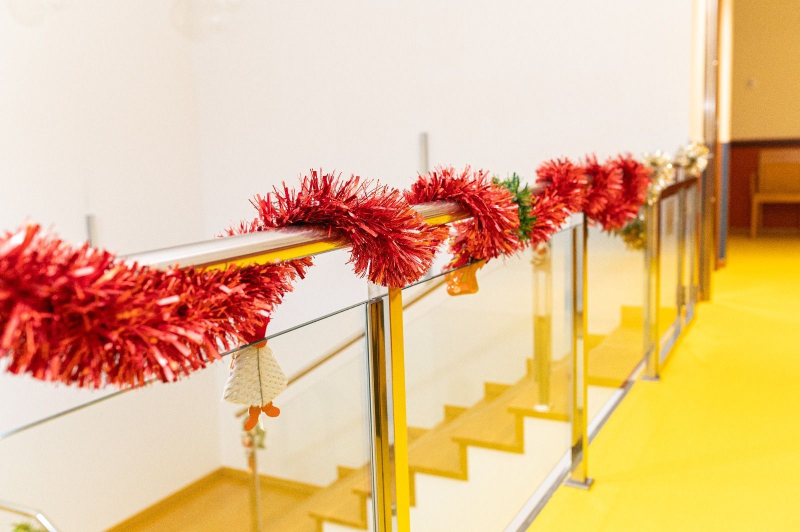 Una escalera decorada para Navidad con oropel rojo y campanas.