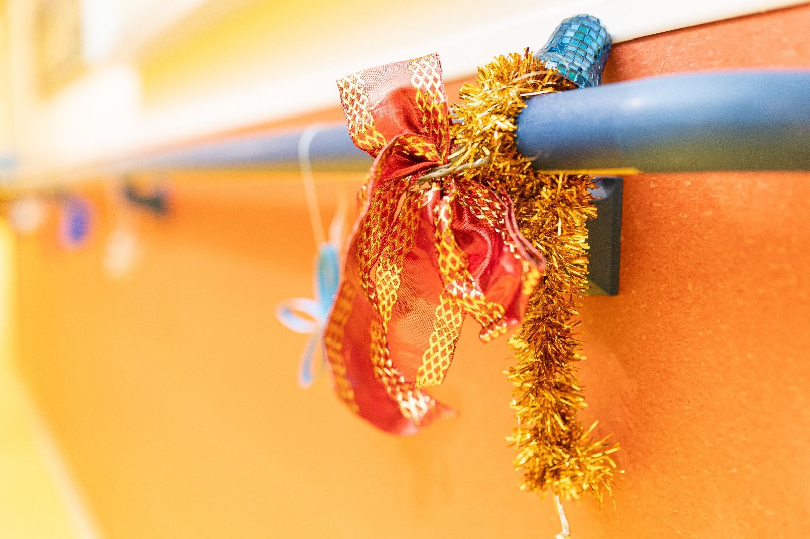 Un primer plano de una barandilla con oropel y un lazo sobre ella.