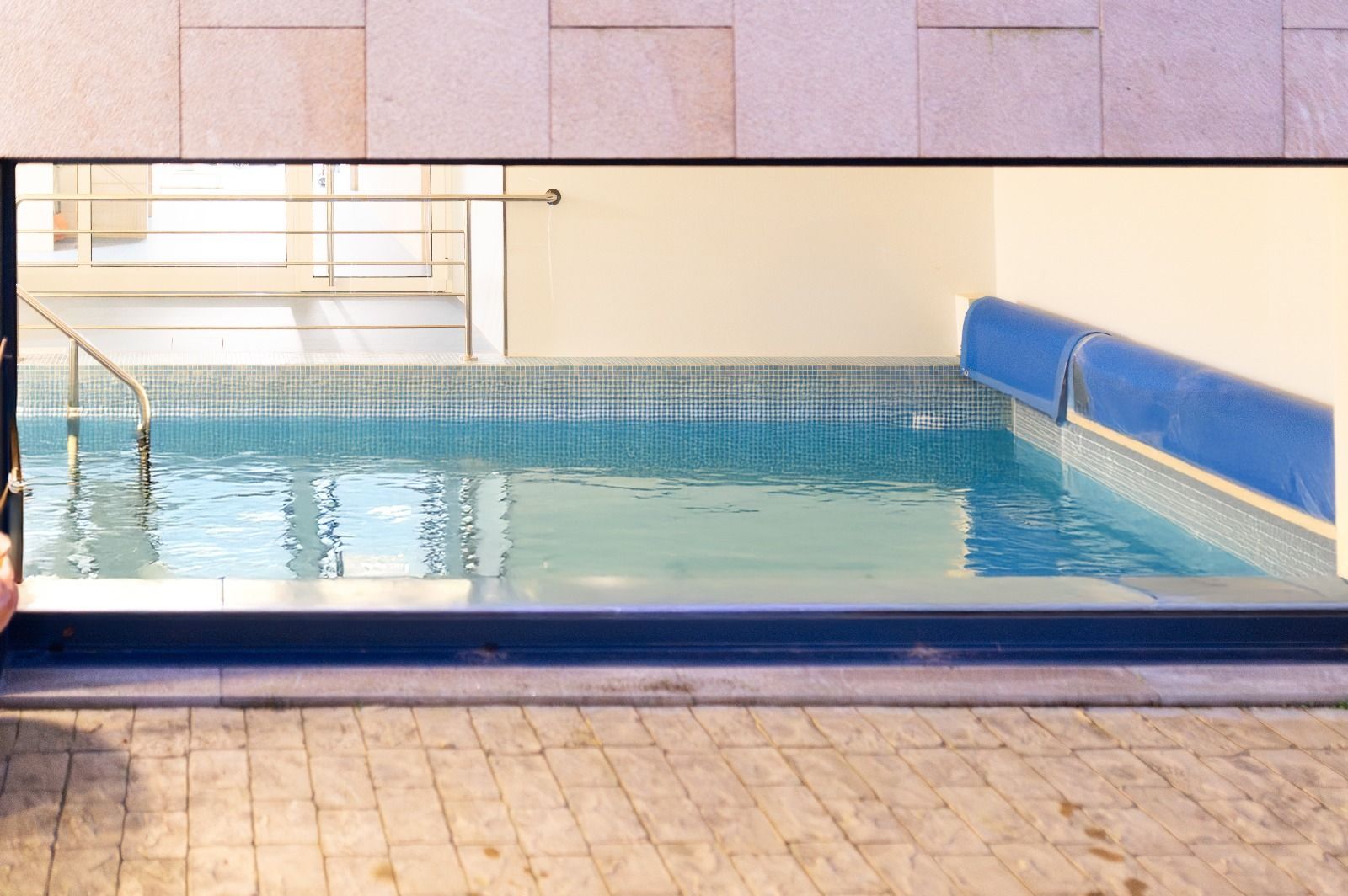 Una persona está parada frente a una piscina.