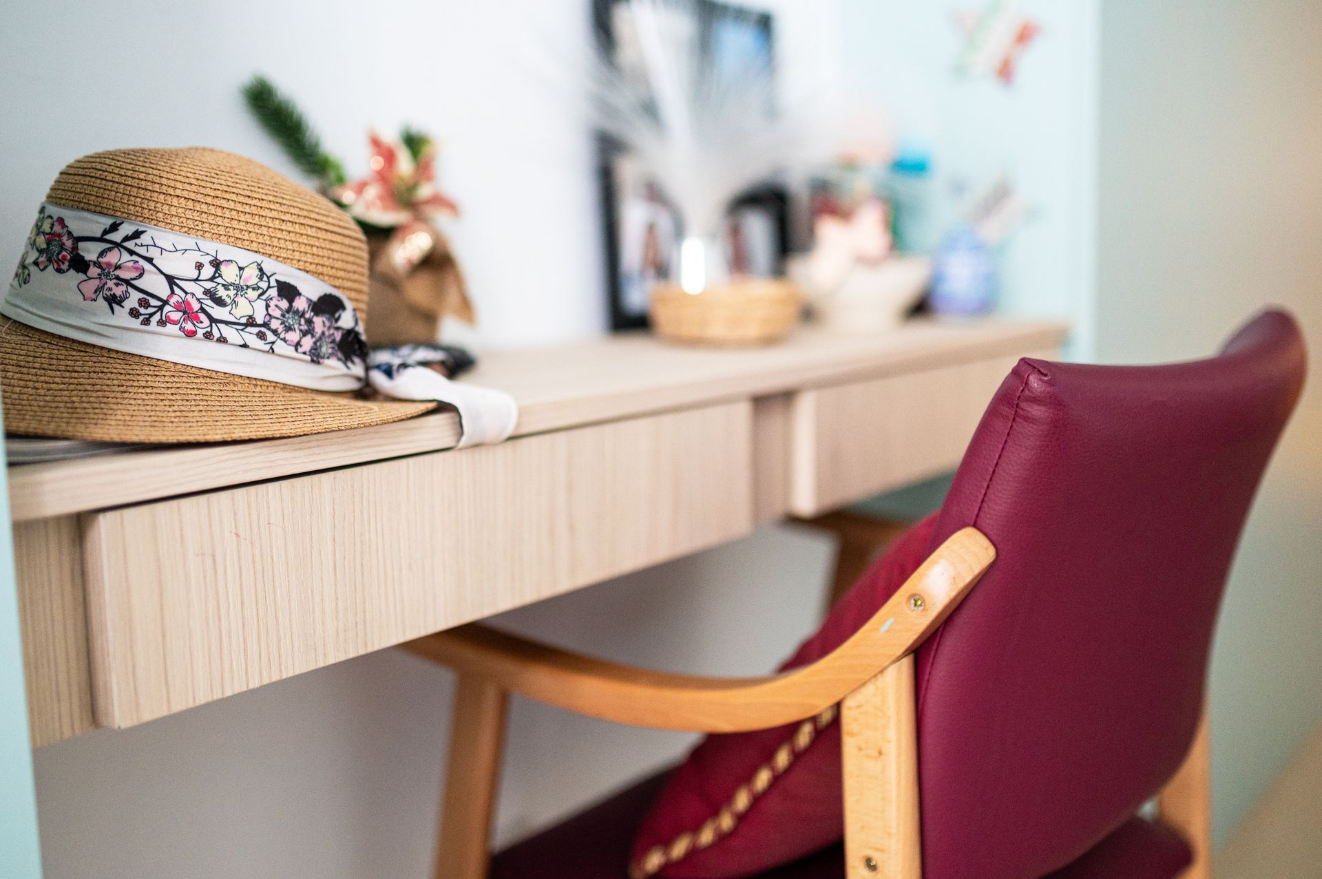 Un sombrero de paja está sobre un escritorio al lado de una silla.