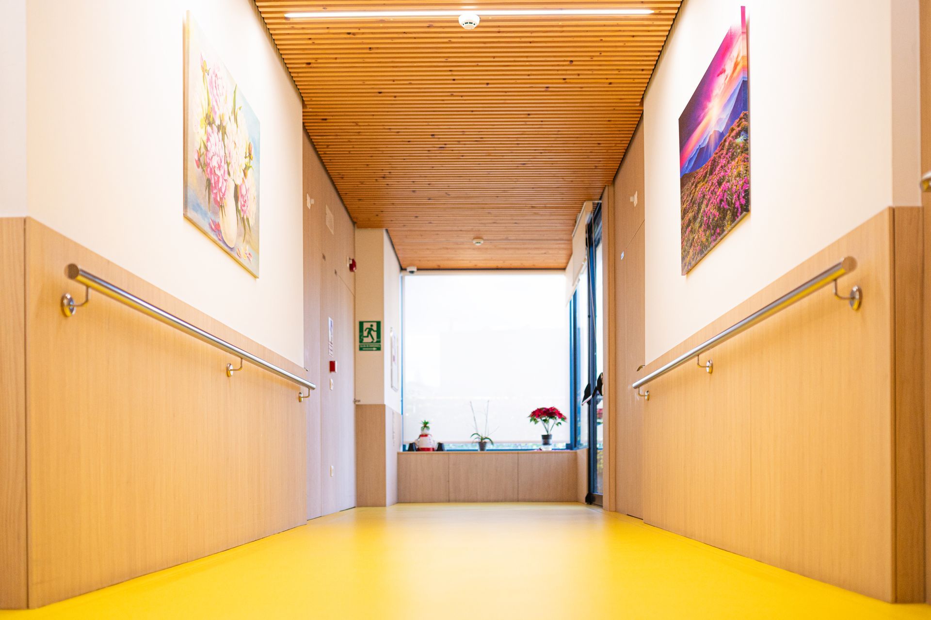 Un largo pasillo con suelo amarillo y paredes de madera.