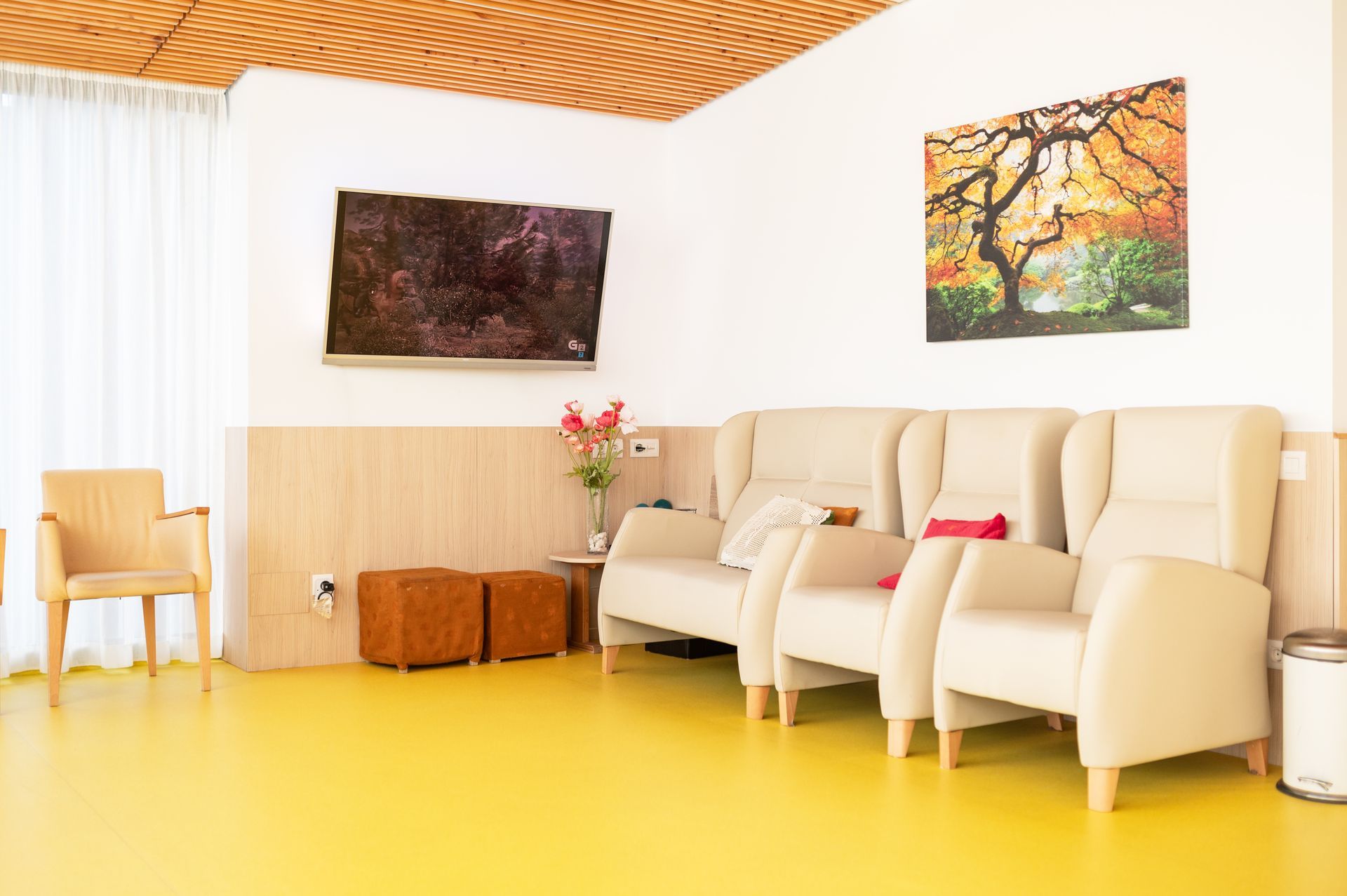 Una sala de estar con suelo amarillo y un sofá y sillas.