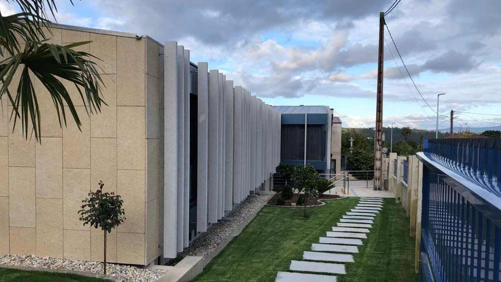Una casa moderna con un exuberante césped verde y una valla azul.