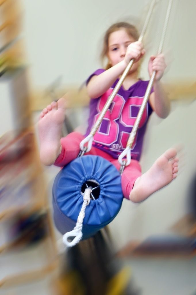 Tyttö keinuu sinisessä keinussa; Activus Oy:n terapiaympäristö