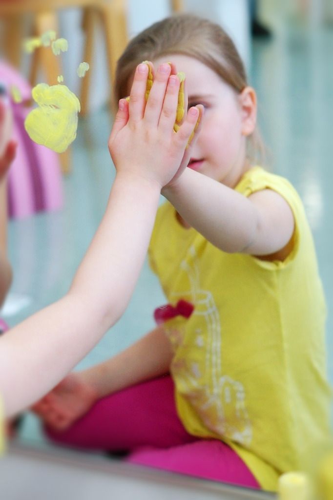 Lapsi painaa keltaisen käden jäljen peiliin; Activus Oy:n terapiaympäristö