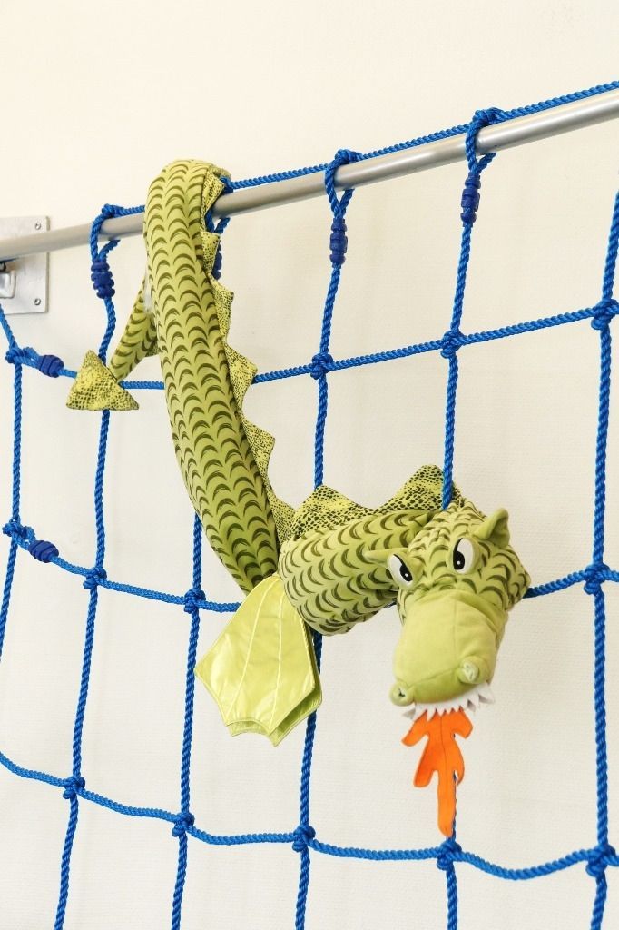 Vihreä pehmolelu lohikäärme sinisellä köysikiipeilyverkolla; Activus Oy:n terapiaympäristö