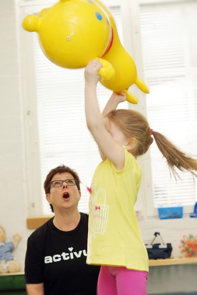 Lapsi nostaa ilmaan keltaista isoa leluponia; Activus Oy:n terapiaympäristö