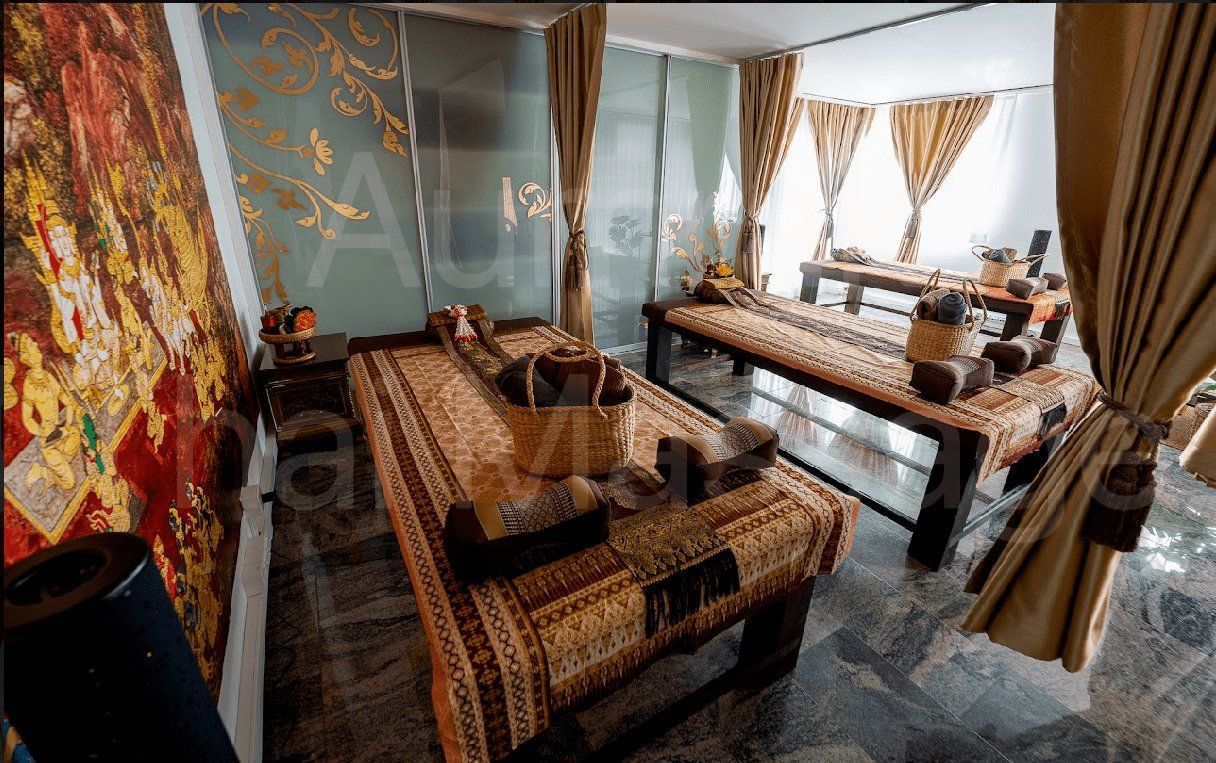 Gemütliches Wohnzimmer mit gemusterten Sofas, einem Couchtisch, Vorhängen und dekorativen Wandbehängen.