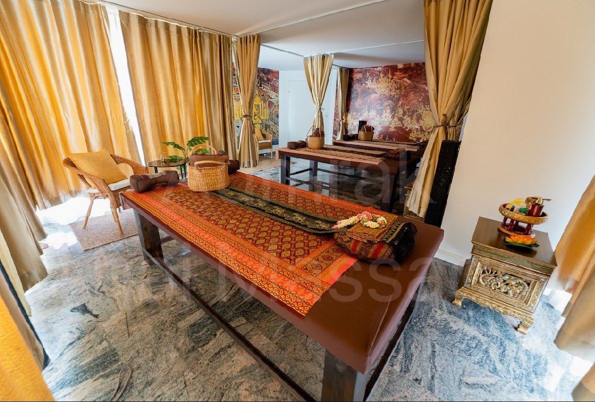 Elegantes Wohnzimmer mit einem langen Holzsofa, goldenen Vorhängen und einem polierten Marmorboden.