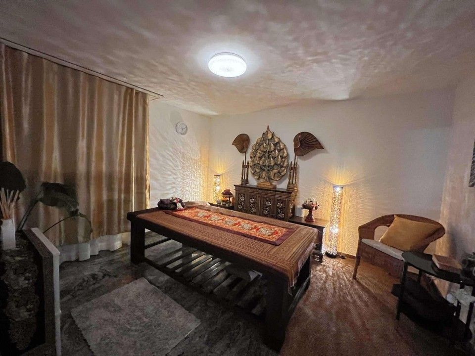 Gemütliches Schlafzimmer mit niedrigem Bett, warmem Licht, Vorhängen und dekorativer Wandkunst