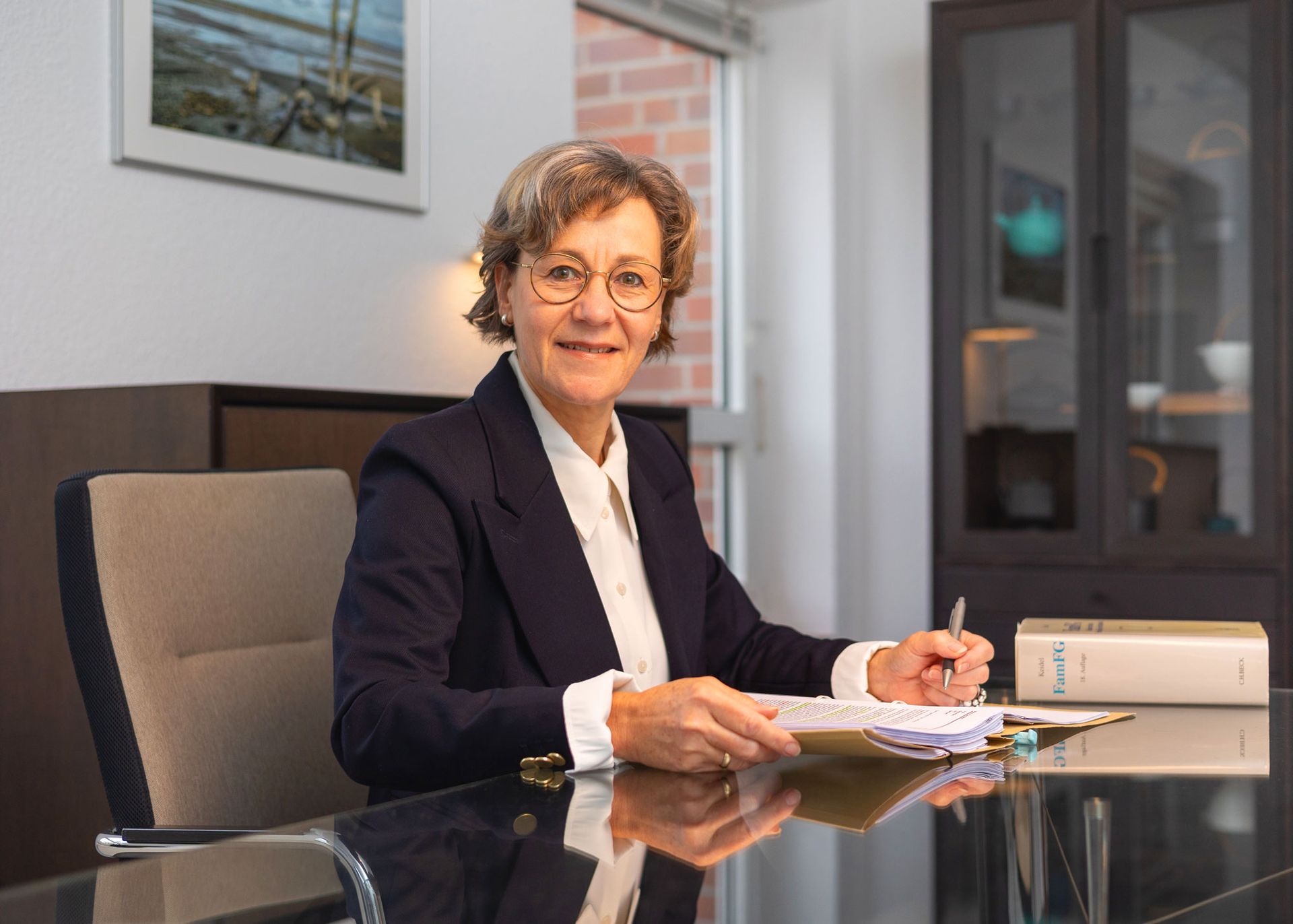 Ein Mann in Anzug und Krawatte sitzt an einem Schreibtisch