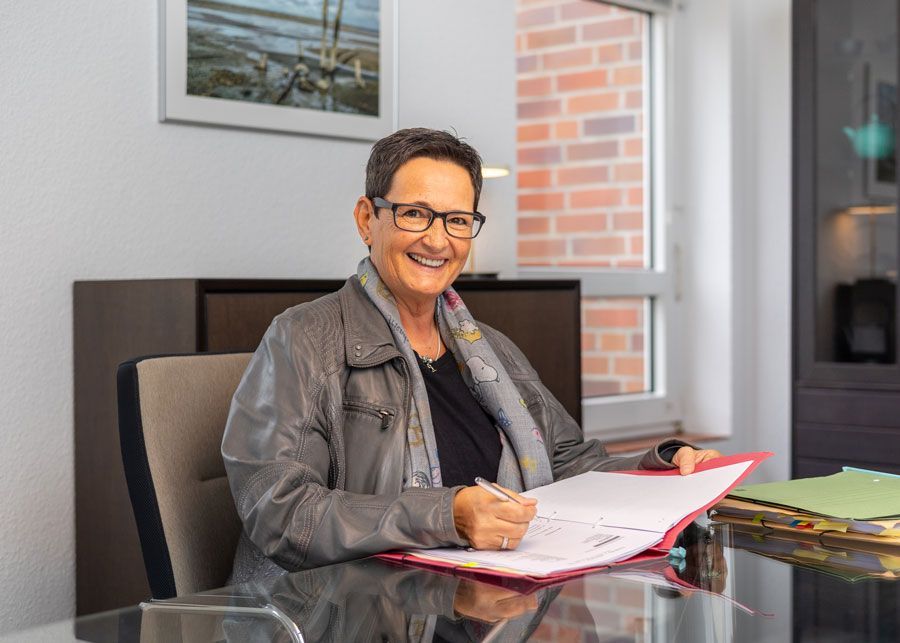 Die Silhouette einer Frau ohne Gesicht steht mit den Händen in den Hüften.