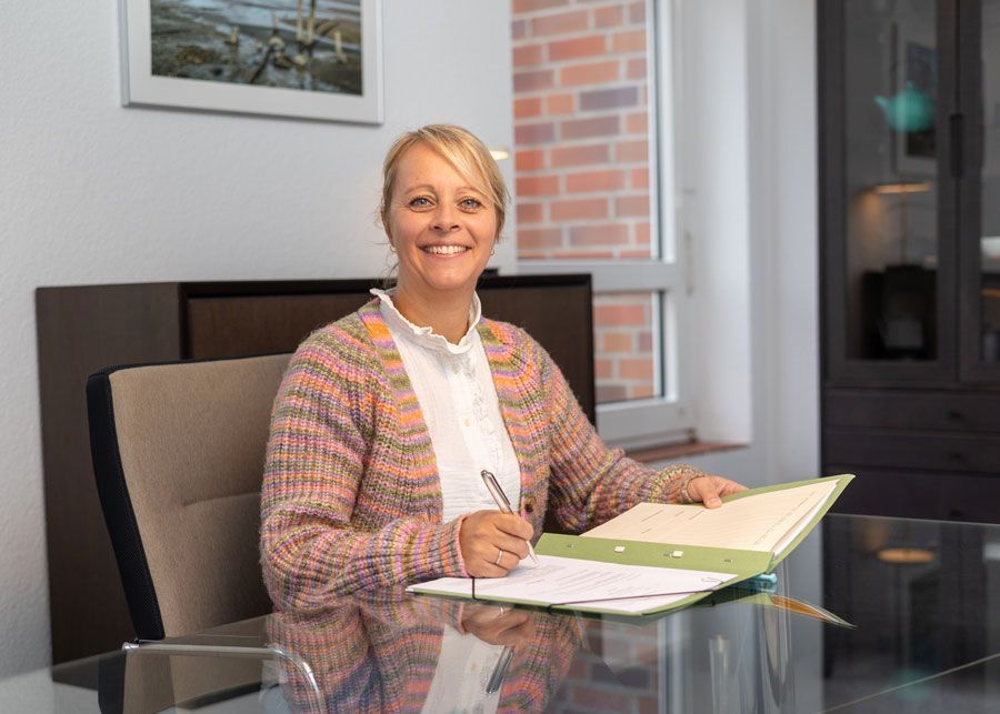 Die Silhouette einer Frau ohne Gesicht steht mit den Händen in den Hüften.