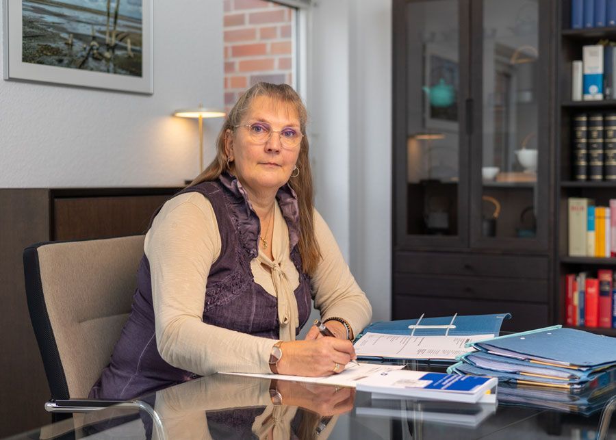 Die Silhouette einer Frau ohne Gesicht steht mit den Händen in den Hüften.