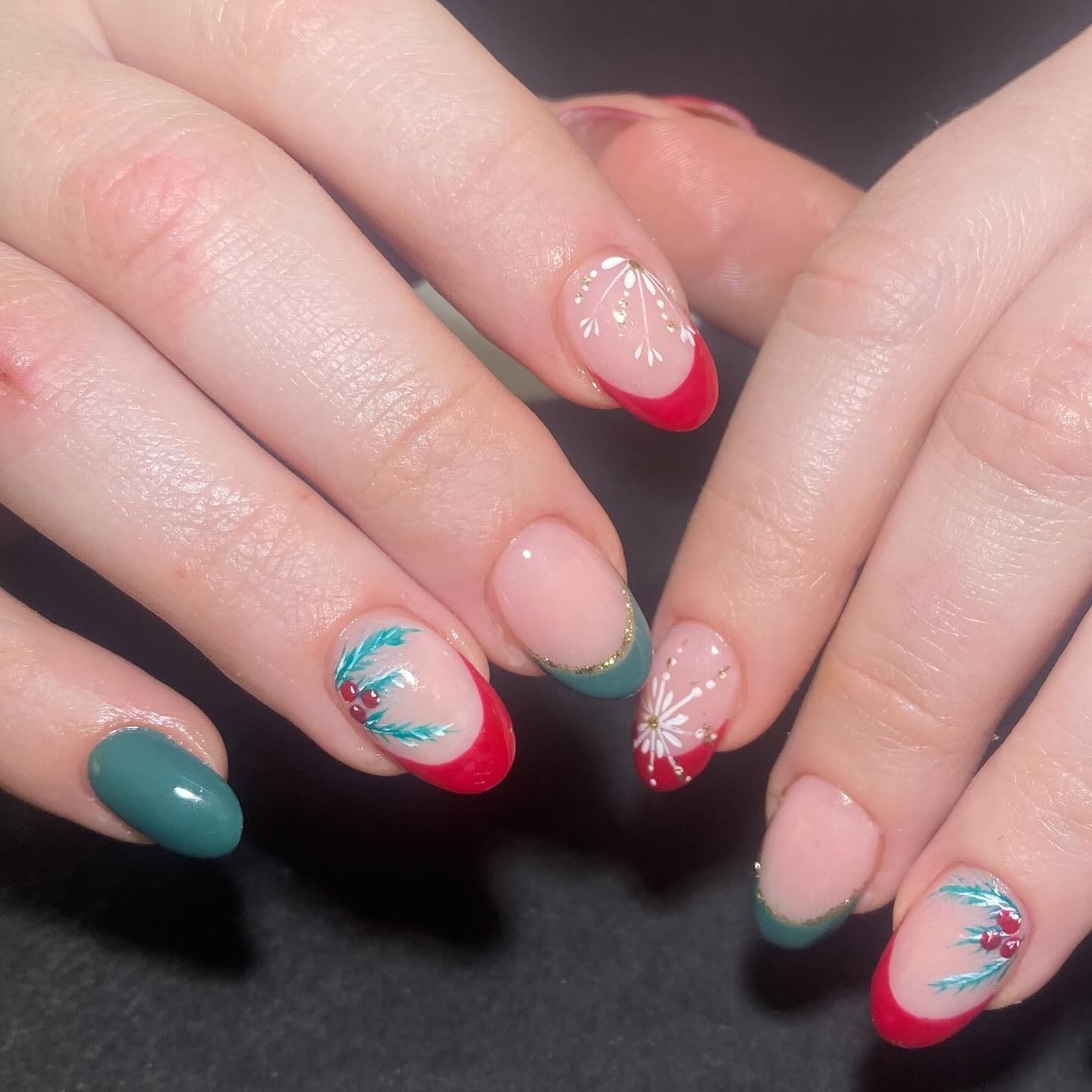 Un primer plano de las uñas de una mujer con una manicura francesa roja.