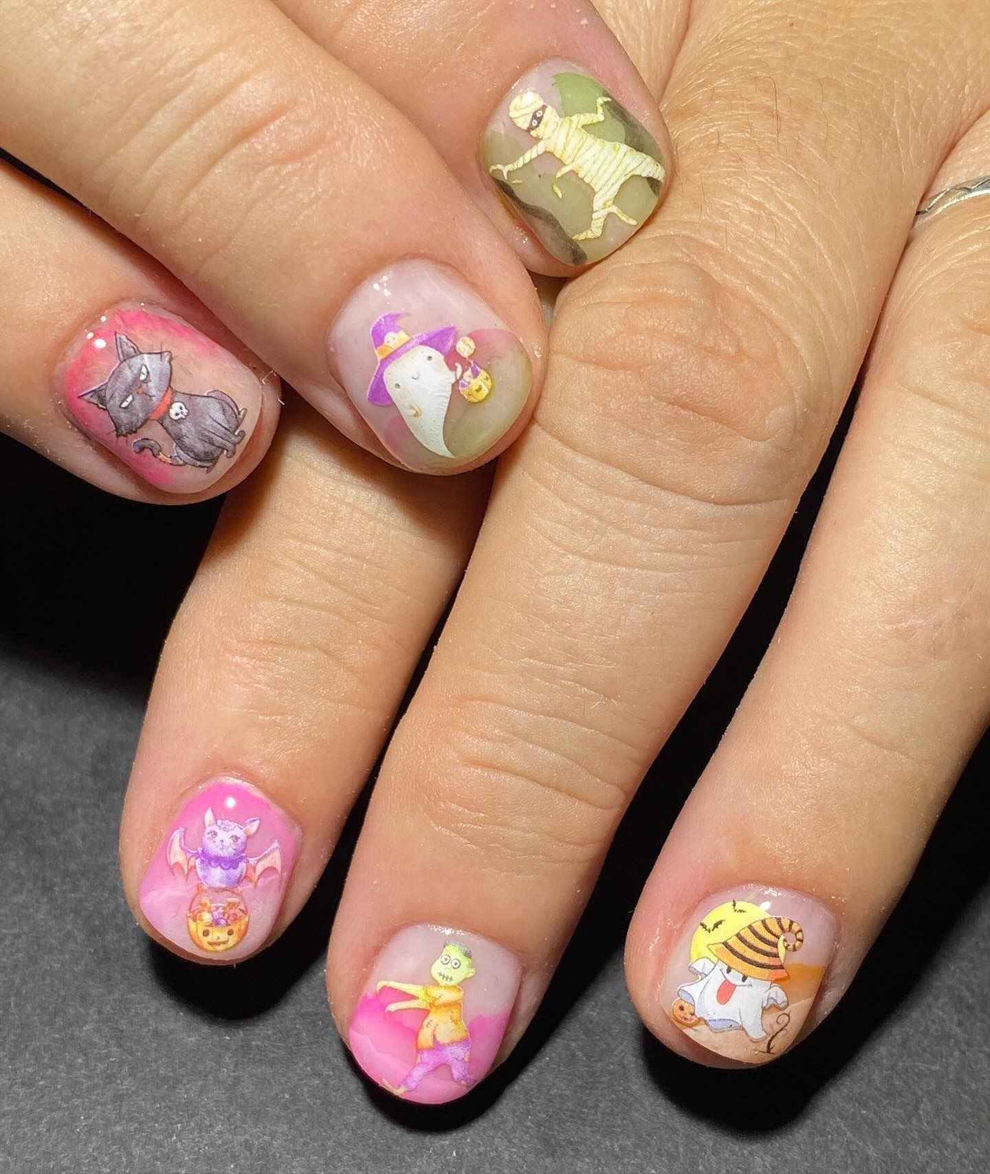 Un primer plano de las uñas de una persona con animales pintados en ellas.